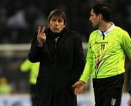 Juventus head coach Antonio Conte (L) talks with a referee assistant on March 16, 2013 in Bologna